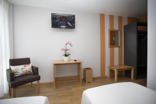 Una televisión o centro de entretenimiento en Hotel Novoa