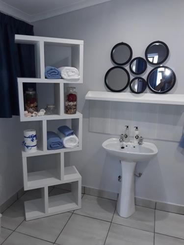 een badkamer met een wastafel en planken met handdoeken bij Ibis Nest in Heidelberg