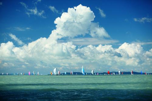 a group of sailboats on the water under a cloudy sky at Balkon Apartmanház Panzió in Balatonfüred