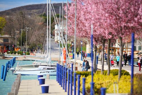 a boat docked at a marina with people walking around at Balkon Apartmanház Panzió in Balatonfüred