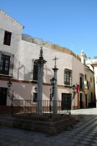 a building with a fountain in the middle of a street at Hotel Patio de las Cruces in Seville