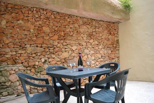 a table with a bottle of wine and four chairs at Le Malte House St. Julians in St Julian's