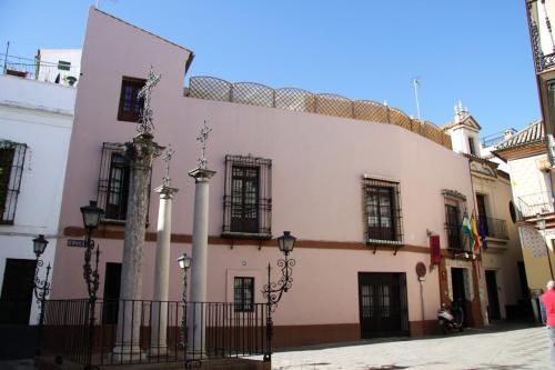 a large white building with black windows and a fence at Hotel Patio de las Cruces in Seville