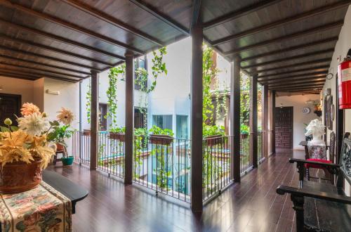 a large room with a balcony with windows at Hotel Patio de las Cruces in Seville