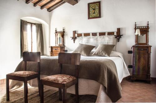 a bedroom with a bed with two chairs at Casa Donella B&B in Gricignano