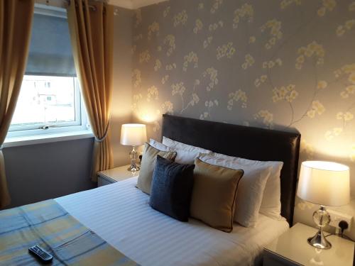 a bedroom with a bed with two lamps and a window at Manchester House in Blackpool