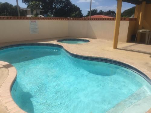 a large swimming pool in a patio with a tile floor at Comfortable Apartment in Boqueron - cash only in Cabo Rojo