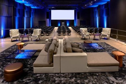 a room with couches and chairs and a projection screen at Revere Hotel Boston Common in Boston