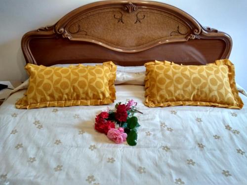 a bed with two pillows and a bunch of flowers on it at Il Melicucco in Furci Siculo