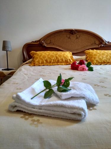 a bed with towels and flowers on it at Il Melicucco in Furci Siculo