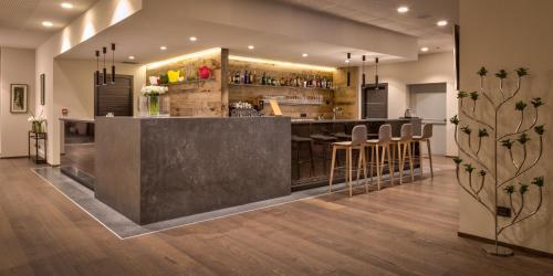 a bar in a room with a counter and stools at Hotel The Cube in Fidenza