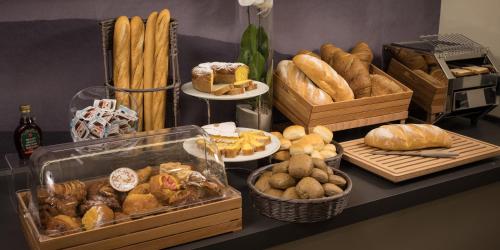 a table topped with lots of different types of bread at Hotel The Cube in Fidenza