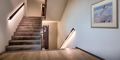 a staircase in a building with a painting on the wall at Hotel The Cube in Fidenza