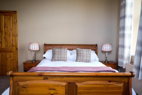 a bedroom with a wooden bed with two lamps at York House Durham in Durham