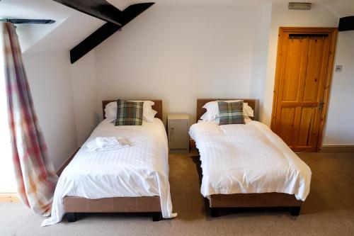 two twin beds in a room with a window at York House Durham in Durham