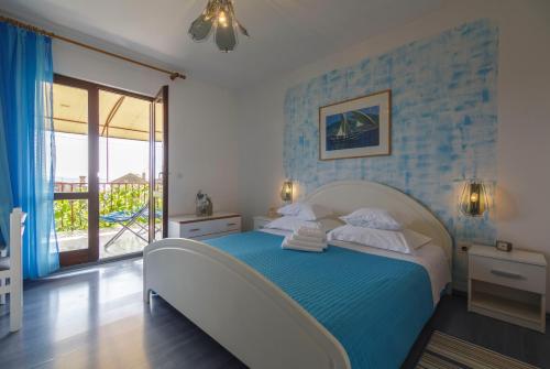 a bedroom with a bed with a blue wall at Villaina in Komiža