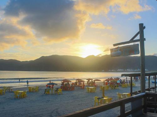 a beach with a bunch of tables and chairs on the sand at Pousada Estrelas no Mar Florianópolis in Florianópolis