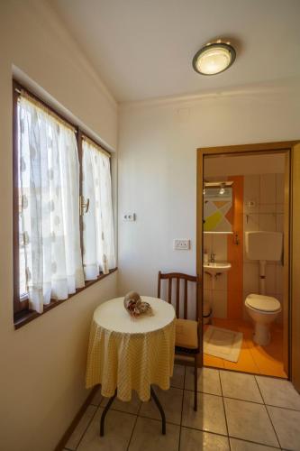a room with a table and a bathroom with a toilet at Villaina in Komiža