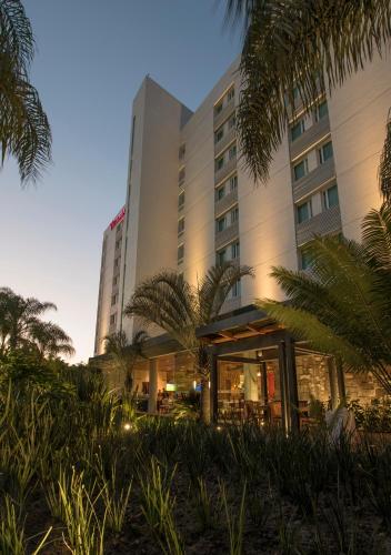 a hotel with palm trees in front of it at Victoria Ejecutivo in Guadalajara