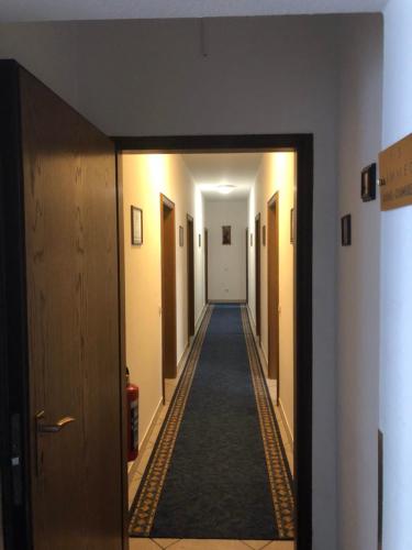 a corridor of a hallway with a long hallway at Hotel Landhaus Köln in Lindlar