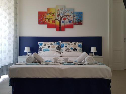 sypialnia z dużym łóżkiem z dwoma obrazami na ścianie w obiekcie B&B Flora w mieście Piazza Armerina