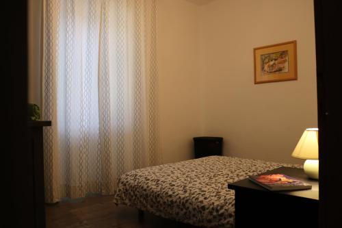 Schlafzimmer mit einem Bett und einem Fenster mit Vorhängen in der Unterkunft Villa Zwei Zedern in Pićan