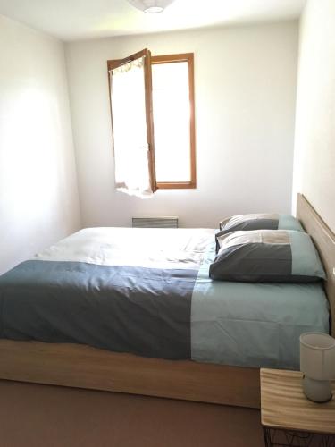 - une chambre avec un lit et une fenêtre dans l'établissement Au cœur de Saint-Jorioz, à Saint-Jorioz
