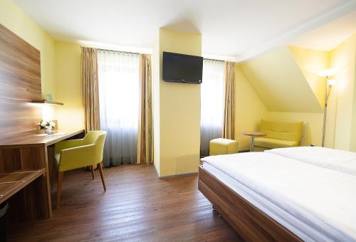 ein Hotelzimmer mit einem Bett, einem Schreibtisch und einem Computer in der Unterkunft Hotel Meyer in Hildesheim