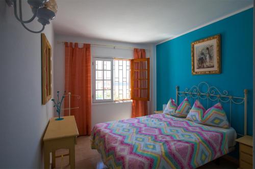 a bedroom with a bed and a blue wall at Apartamento Marina in Puerto del Carmen