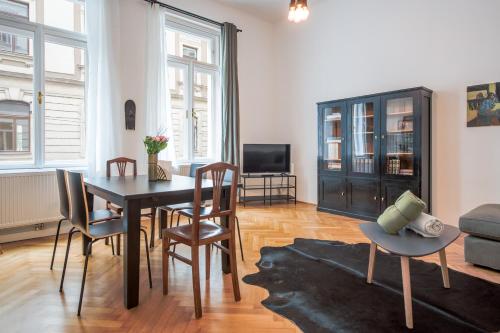 a living room with a dining room table and chairs at GRAND SOHO II Apartment Vienna in Vienna