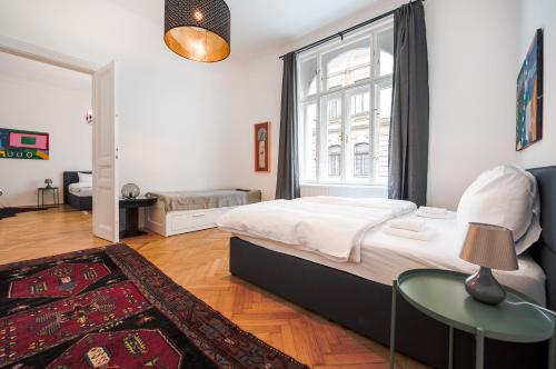ein Schlafzimmer mit einem Bett und einem großen Fenster in der Unterkunft GRAND SOHO II Apartment Vienna in Wien