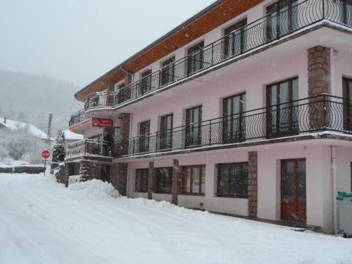 a pink building with snow on the ground at Les Jolis Coeurs in Thiéfosse