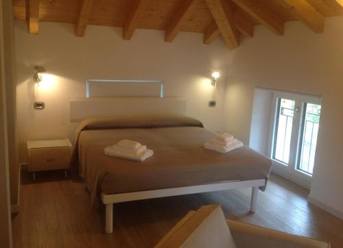 a bedroom with a bed with two towels on it at Appartamento i Tulipani - 2 in Griante Cadenabbia