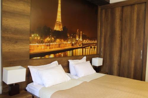 a bedroom with a bed with a picture of the eiffel tower at Freedom Square Apartment in Tbilisi City