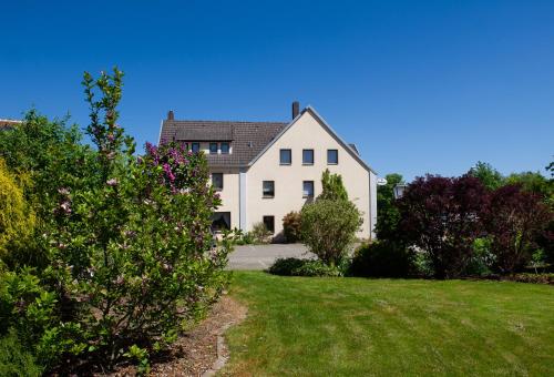a large white house with a yard at Hotel Meyer in Hildesheim