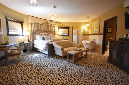 a bedroom with a bed and a sink and a tub at The Detroit Club in Detroit