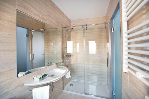 a bathroom with a glass shower and a sink at UVE Alcobendas in Alcobendas