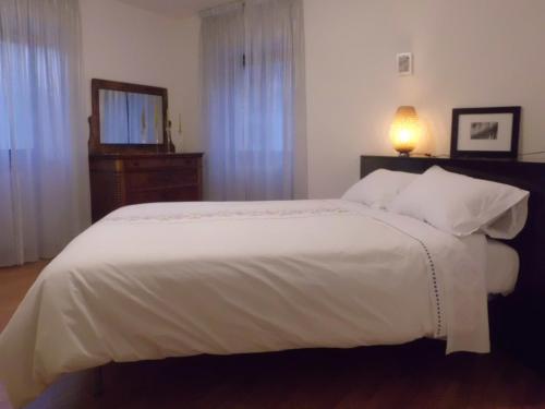 a bedroom with a large white bed and a television at Affittacamere Ca' Fattorini in Baceno