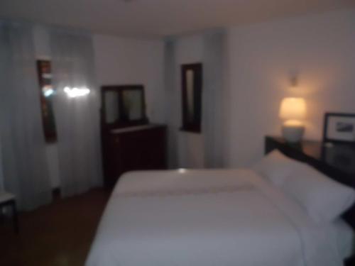 a bedroom with a white bed and two mirrors at Affittacamere Ca' Fattorini in Baceno