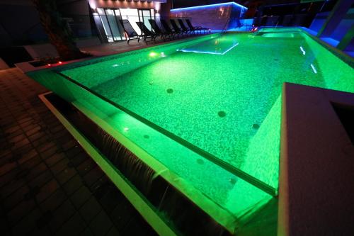 a swimming pool with green lighting in a building at Boutique Apartments Ad Astra in Bibinje