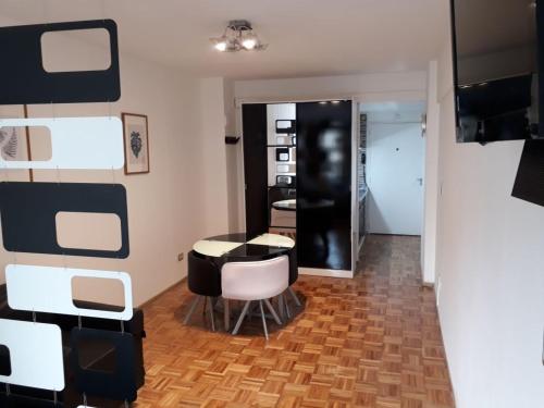 um quarto com uma mesa e cadeiras e uma parede em Downtown Viamonte Apartment em Buenos Aires