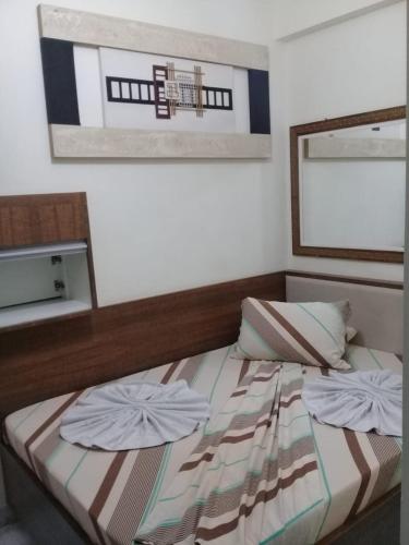 a bed with two pillows on it in a room at Motel Reality in Sao Paulo