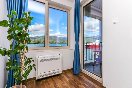 a room with a balcony with a view of the mountains at Apartments Maestral in Tivat