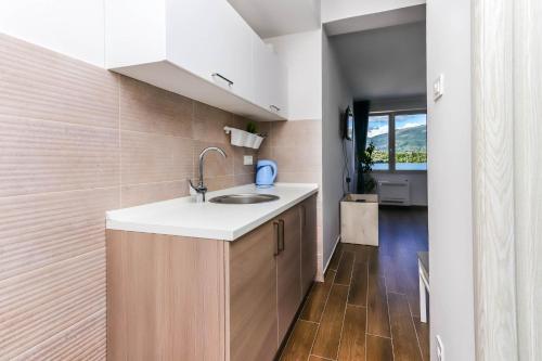 a kitchen with a sink and wooden floors at Apartments Maestral in Tivat