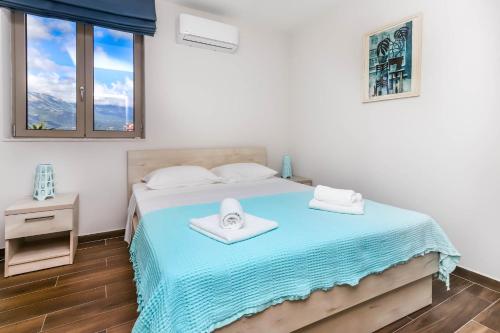 a bedroom with a bed with two towels on it at Apartments Maestral in Tivat