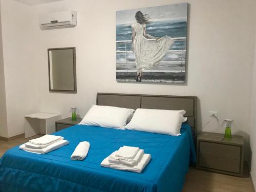 a bedroom with a blue bed with towels on it at Baia Dell'Orso in Torre dell'Orso