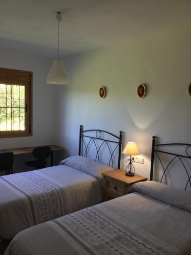 una camera da letto con due letti e una lampada su un tavolo di El cortijo de la abuela a Benahadux