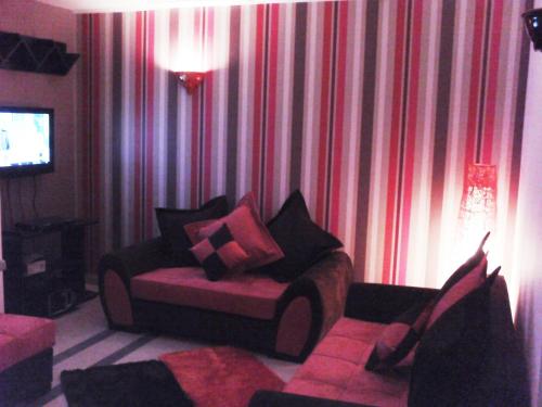 a living room with a couch in front of a curtain at Happy House Ennasr in Ariana