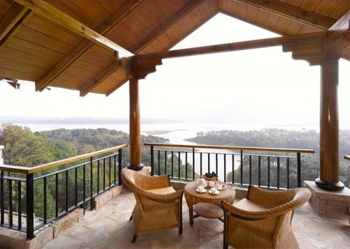 a patio with a table and chairs on a balcony at Ri Kynjai Serenity by The Lake in Shillong