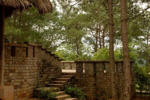 a brick retaining wall with stairs and trees at Ri Kynjai Serenity by The Lake in Shillong